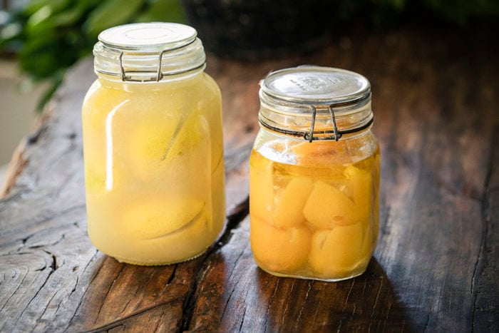 2 contrasting jars of preserved lemons before and after the lemons are preserved.